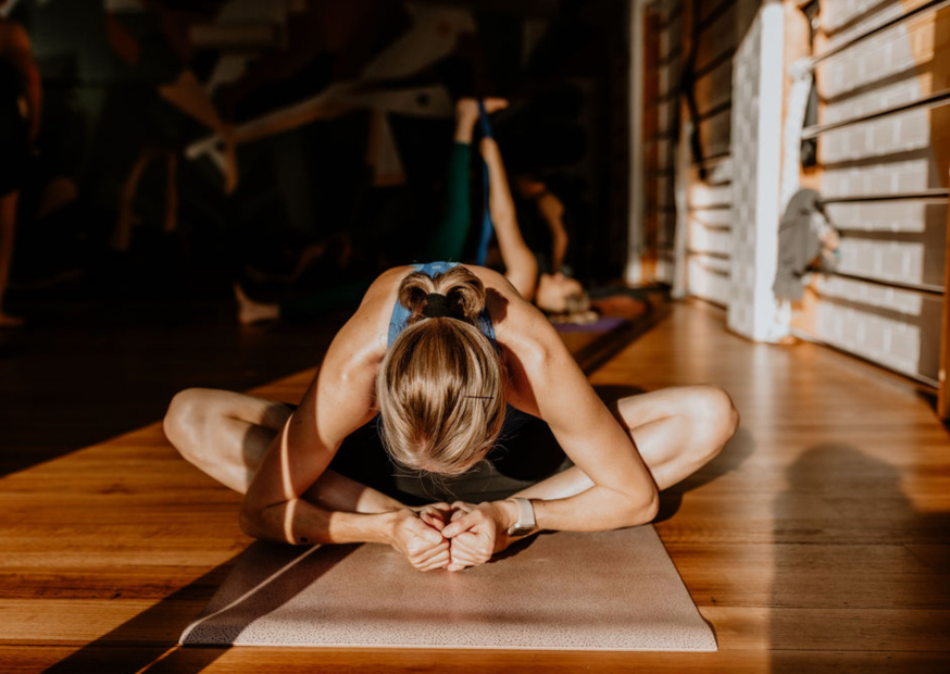 woman doing baddha konasana posture. sunlight streaming in
